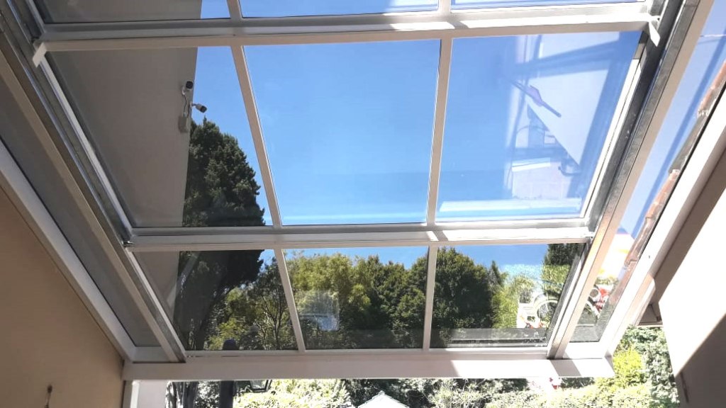 Techo corredizo en aluminio color blanco en patio y jardín con vidrio DVH